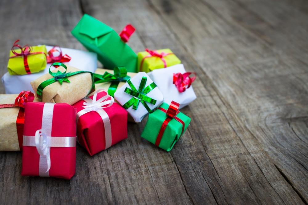 Colorful gift packages tied with ribbons on a wooden surface